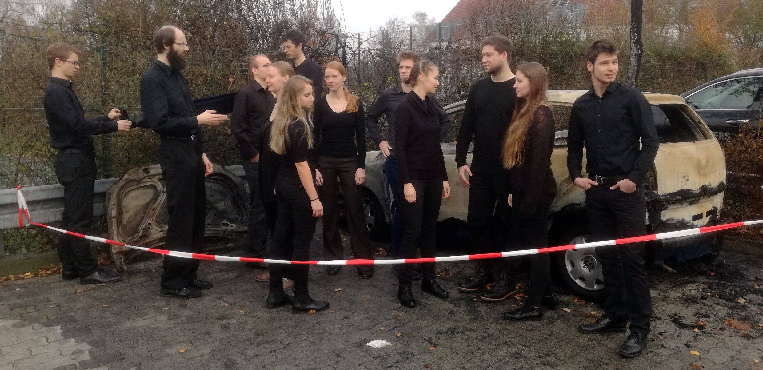 Bayuna vor einem ausgebrannten Auto